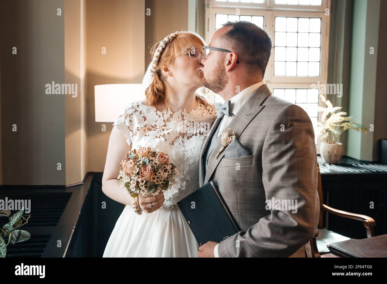 Sposa e sposo che si baciano il giorno del loro matrimonio Foto Stock