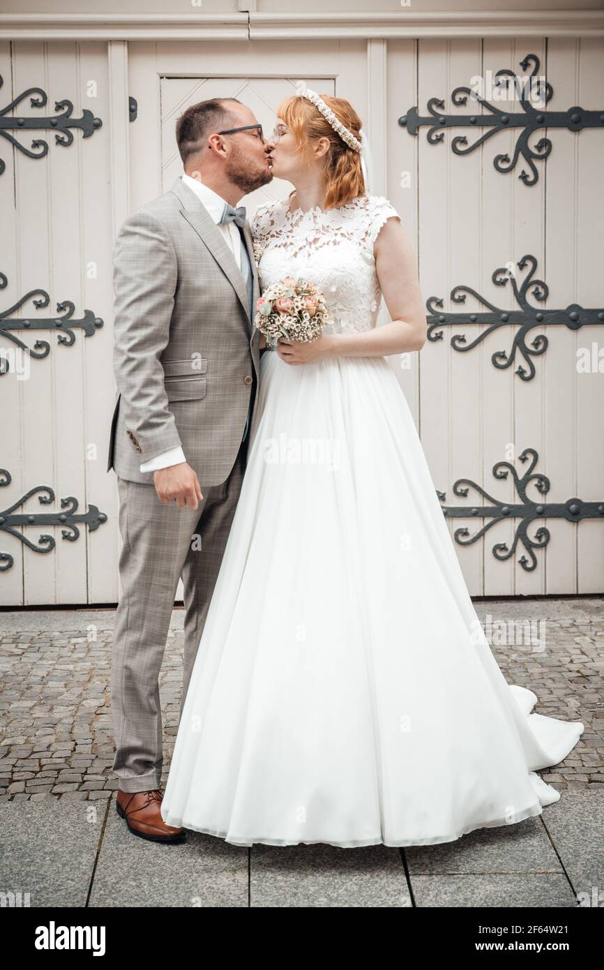 Sposo e sposa che baciano il giorno del matrimonio Foto Stock