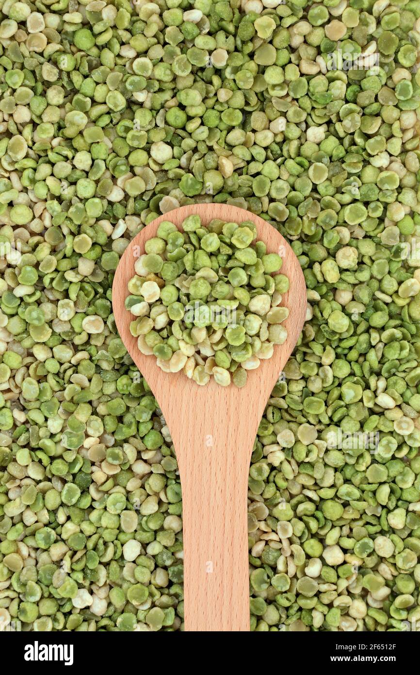 Piselli verdi arrostiti organici cibo sano in un cucchiaio di legno e formando uno sfondo. Alta in fibra dietetica, proteine, vitamine e minerali. Foto Stock