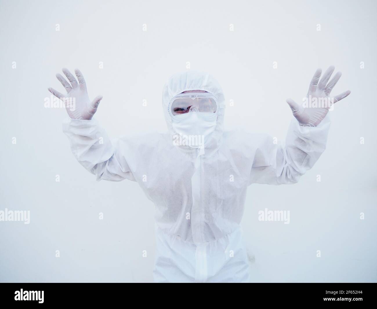 Medico o scienziato asiatico in uniforme della suite PPE che mostra il segno di stop. Coronavirus o COVID-19 concetto isolato sfondo bianco Foto Stock