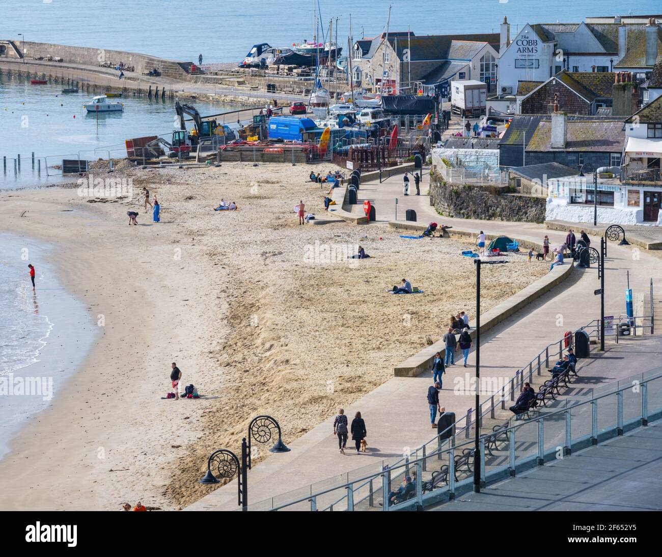 Lyme Regis, Dorset, Regno Unito. 30 Marzo 2021. Regno Unito Meteo: Glorioso caldo e sole tempo alla stazione balneare di Lyme Regis come la Costa Sud crogioli in una mini onda di calore prima del fine settimana di Pasqua in riva al mare. Le persone fanno del meglio del bel tempo per riconnettersi con amici e familiari, mentre il paese si allenta da blocco. Credit: Celia McMahon/Alamy Live News Foto Stock