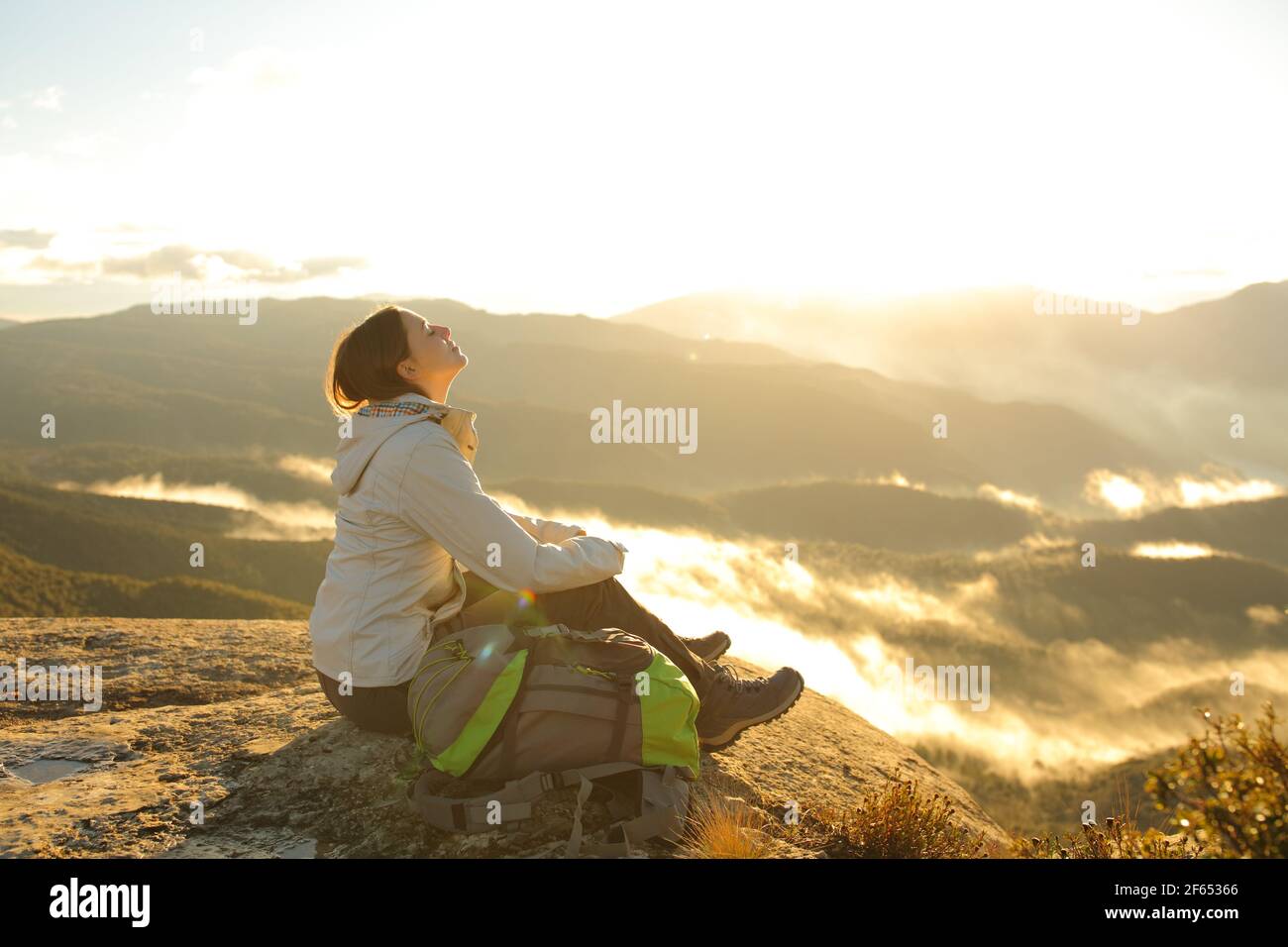 Happy Trekker respirando aria fresca nella parte superiore di a. montagna all'alba Foto Stock