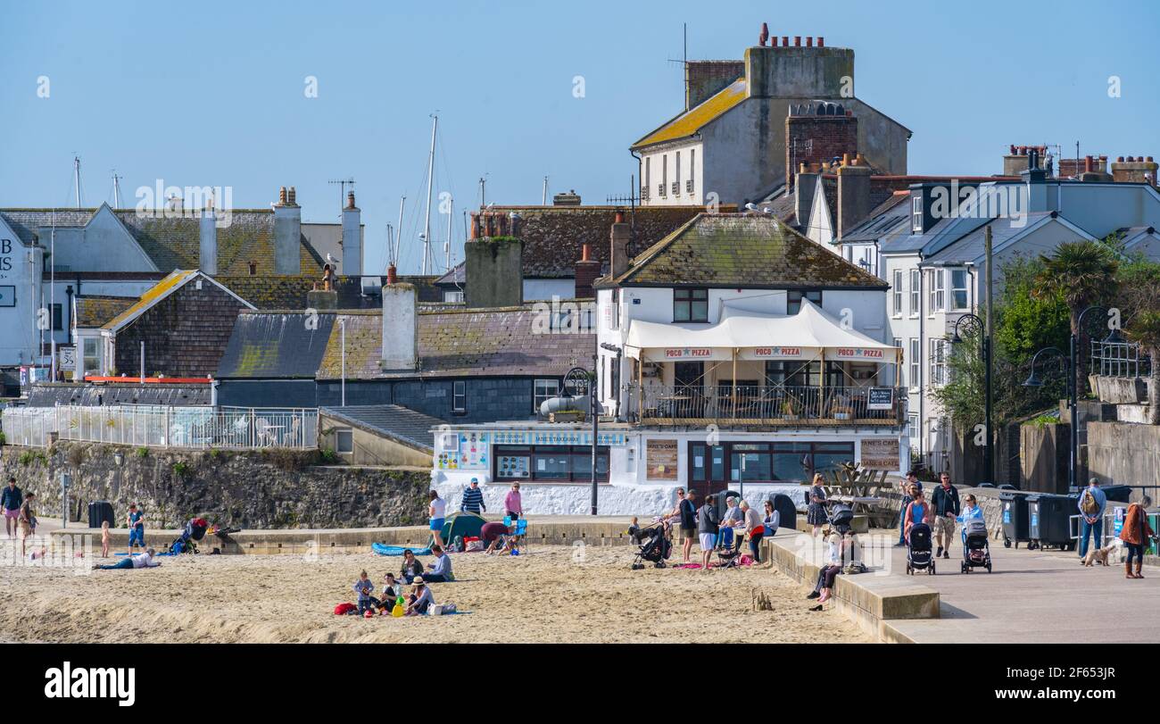 Lyme Regis, Dorset, Regno Unito. 30 Marzo 2021. Regno Unito Meteo: Glorioso caldo e sole tempo alla stazione balneare di Lyme Regis come la Costa Sud crogioli in una mini onda di calore prima del fine settimana di Pasqua in riva al mare. Le persone fanno del meglio del bel tempo per riconnettersi con amici e familiari, mentre il paese si allenta da blocco. Credit: Celia McMahon/Alamy Live News Foto Stock