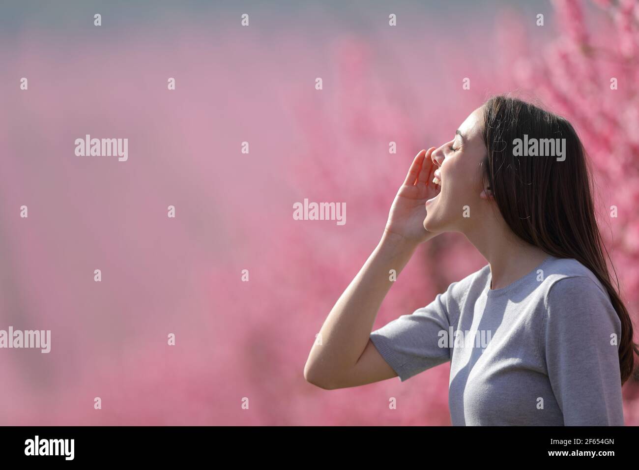 Profilo di una donna felice gridando in un campo in stagione primaverile Foto Stock