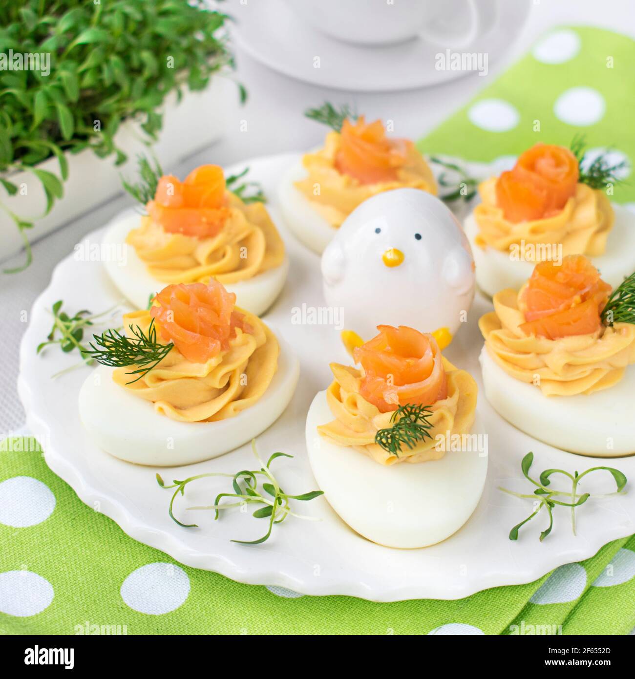 Uova farcite con pasta di salmone affumicata, decorate con pezzi di salmone e aneto fresco. Foto Stock