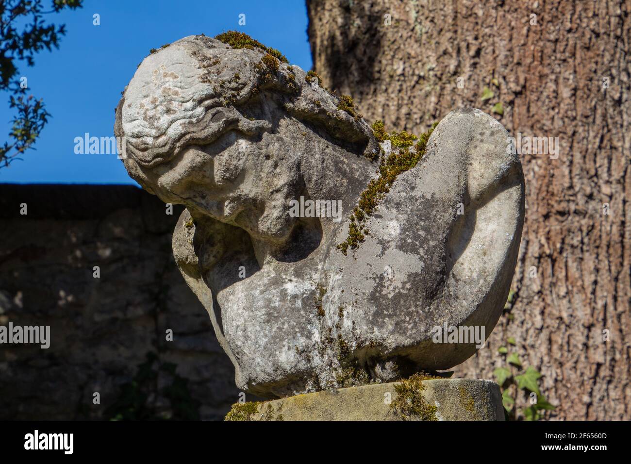 Antica statua danneggiata di Gesù ricoperta di muschio Foto Stock