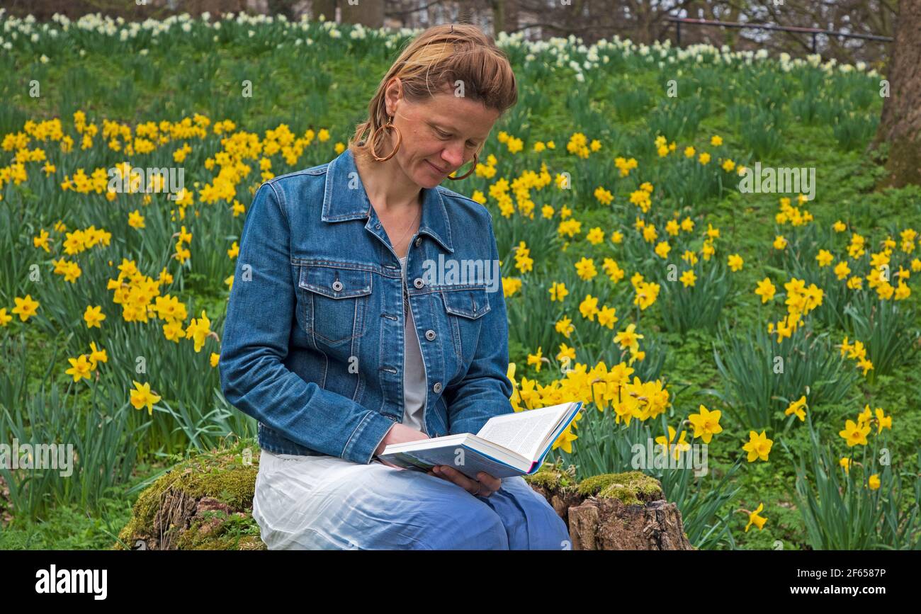 Edimburgo, Scozia, Regno Unito. 30 marzo 2021. Nuvoloso nel bosco, temperatura 15 gradi centigradi. Anna Neubert-Wood di WanderWomen Scozia gode della pace e della solitudine rilassarsi tra i narcisi dorati. Anna ama condividere la sua passione per gli spazi aperti con le donne che hanno la stessa mentalità: Per fare escursioni in luoghi bellissimi con tutto ciò di cui ha bisogno nello zaino, vagare e trovare meraviglia nella natura, essere Uniti con ciò che circonda lei e i suoi compagni. Foto Stock