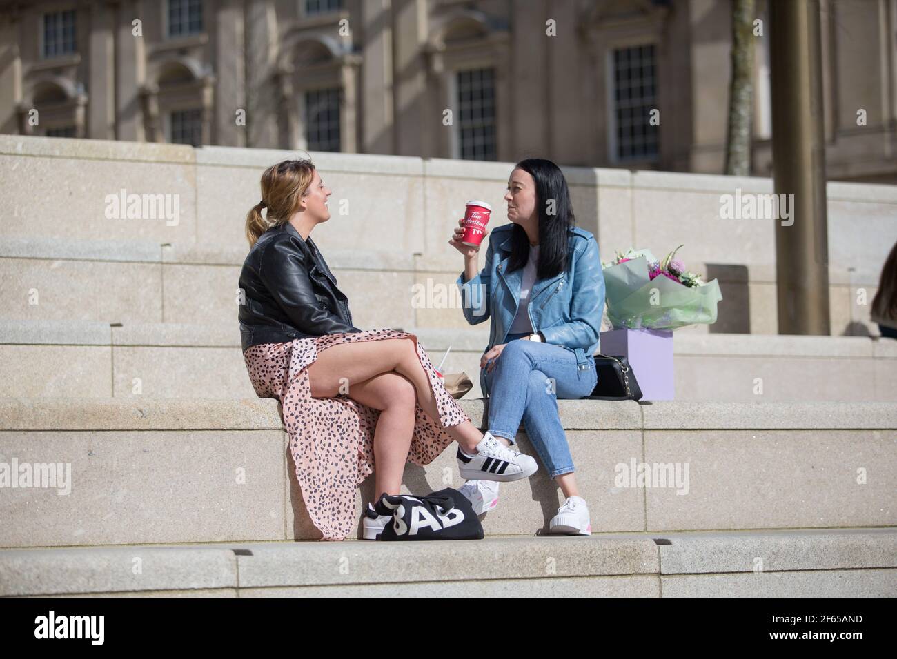 Birmingham, Regno Unito. 30 Marzo 2021. Gli impiegati si rilassano al sole nella recentemente sviluppata Chamberlain Square nel centro di Birmingham. Credit: Peter Lopeman/Alamy Live News Foto Stock