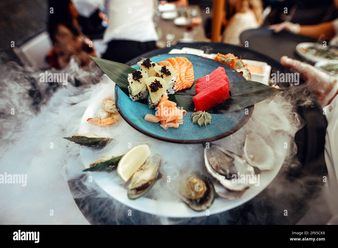 Piatto con ostriche e frutti di mare in un ghiaccio e fumo Foto Stock