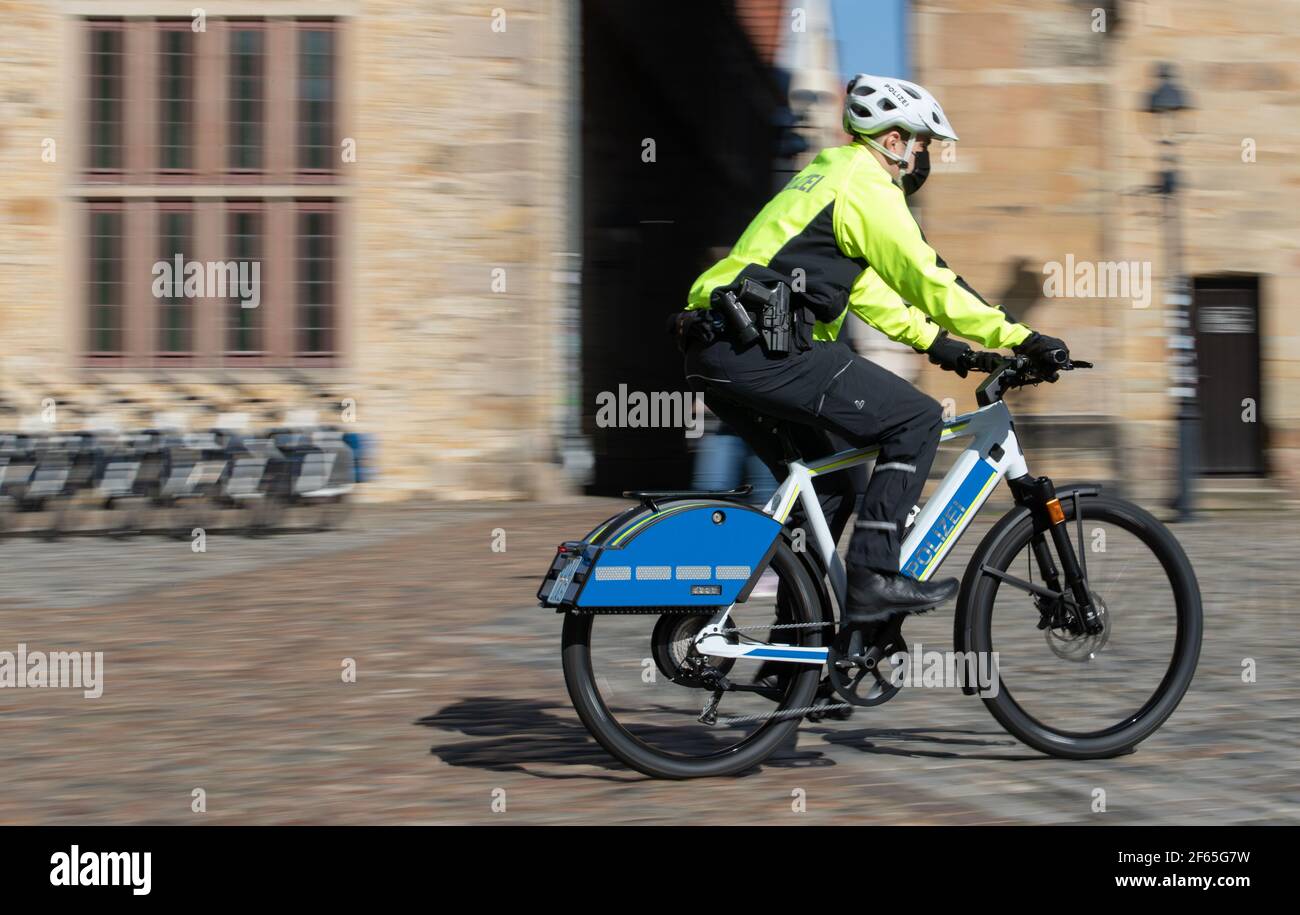 30 marzo 2021, bassa Sassonia, Osnabrück: Un poliziotto guida un S-pedelec con speciali apparecchiature di segnalazione come la luce blu e la sirena. Nell'area di Osnabrück, due pedine veloci con apparecchiature di segnalazione saranno testate dagli ufficiali nei prossimi dodici mesi, secondo la polizia di Osnabrück. Le bici elettriche, che sono fino a 45 chilometri all'ora veloci, sono contribuire a rendere la polizia più amichevole ai cittadini. Con le moto, non c'è più una finestra ostruttiva tra ufficiali e cittadini, come nel caso delle vetture di pattuglia. Foto: Frito Gentsch/dpa Foto Stock