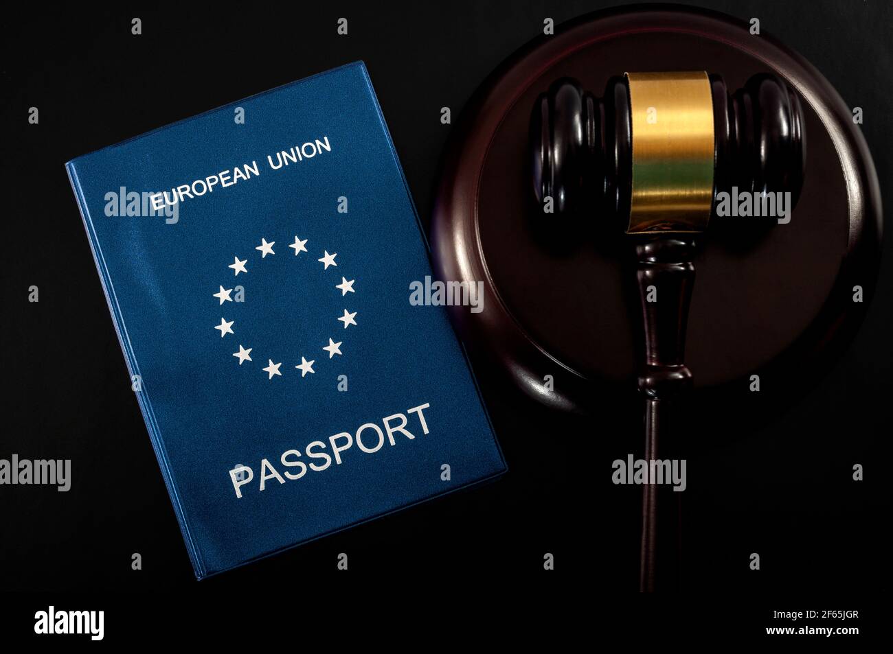 Diritti dei cittadini dell'UE e concetto europeo di libertà di circolazione con primo piano su un passaporto europeo accanto a una navata su sfondo scuro Foto Stock