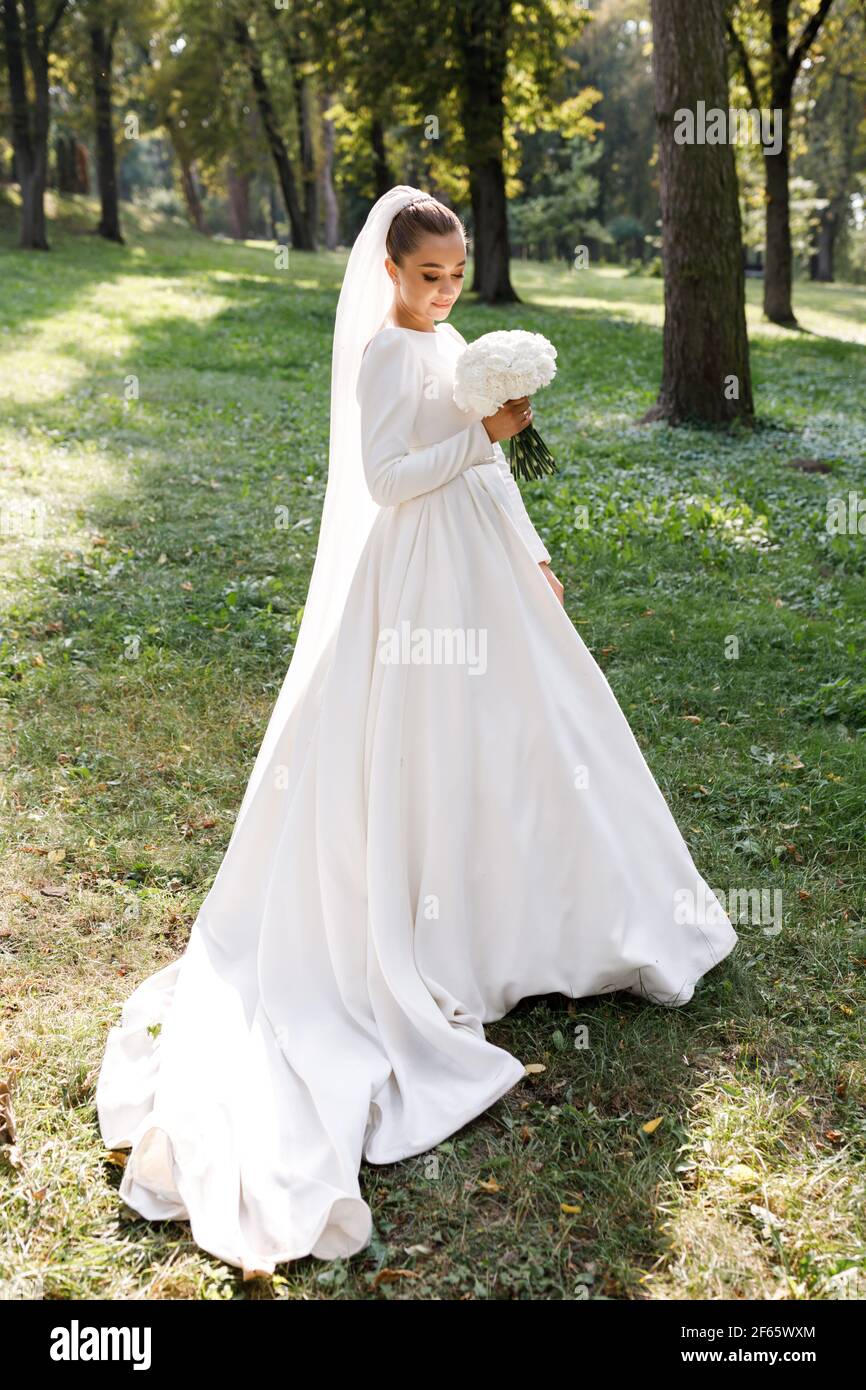 Ritratto di una bella sposa bionda con fiori nel parco Foto Stock