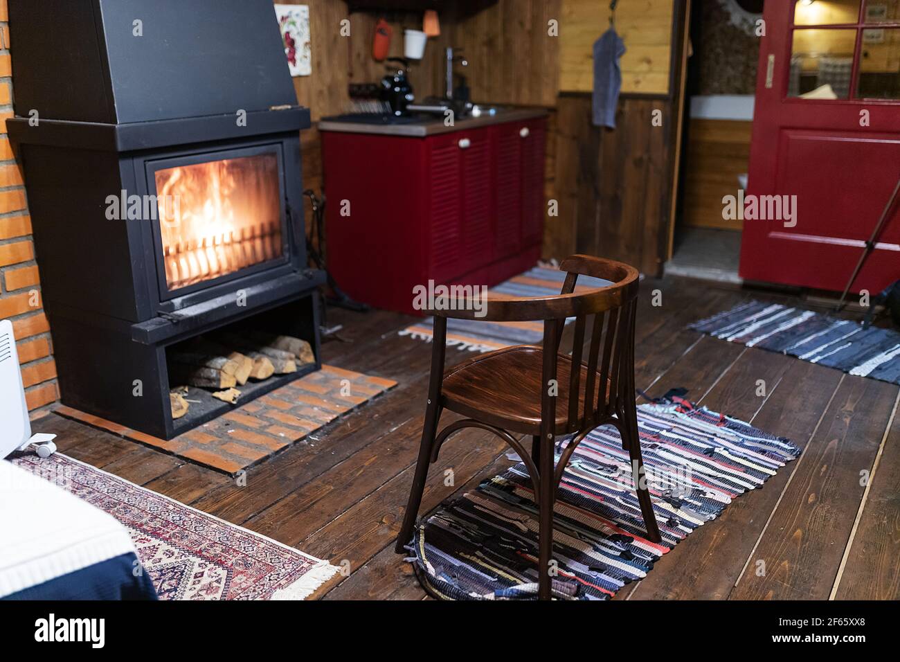 camino domestico. interno accogliente di una casa di campagna. camino in pietra d'epoca in camera. una fiamma calda si rincola nel forno Foto Stock