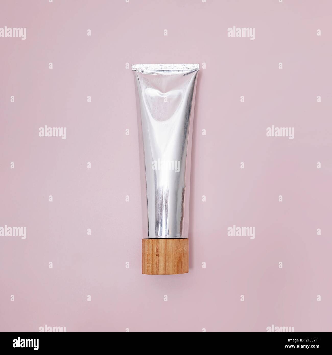 Tubo metallico di dentifricio naturale su rosa Foto Stock