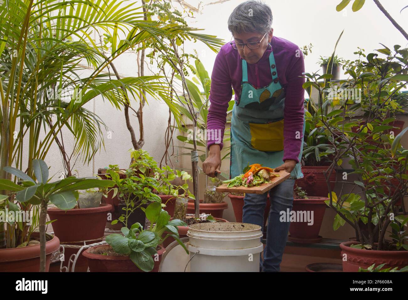 Una donna che fa il composto dai avanzi della cucina Foto Stock