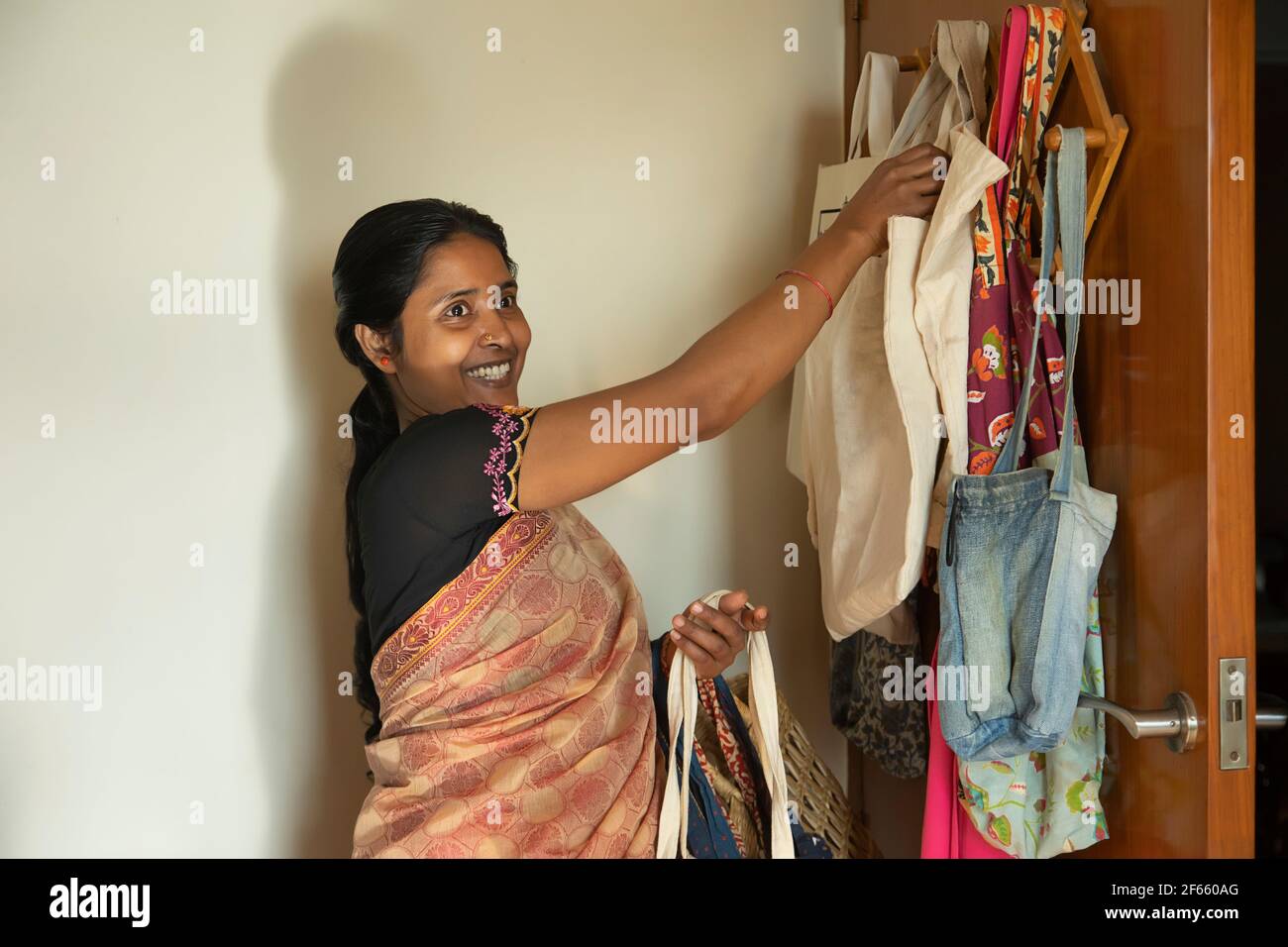 Una casa-maker che porta borse di tessuto riutilizzabili per lo shopping Foto Stock