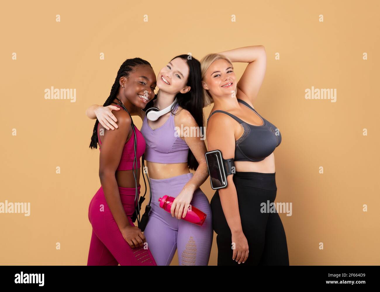 Concetto di diversità. Gruppo di femmine multietniche felici che si pongono insieme in Sportswear Foto Stock