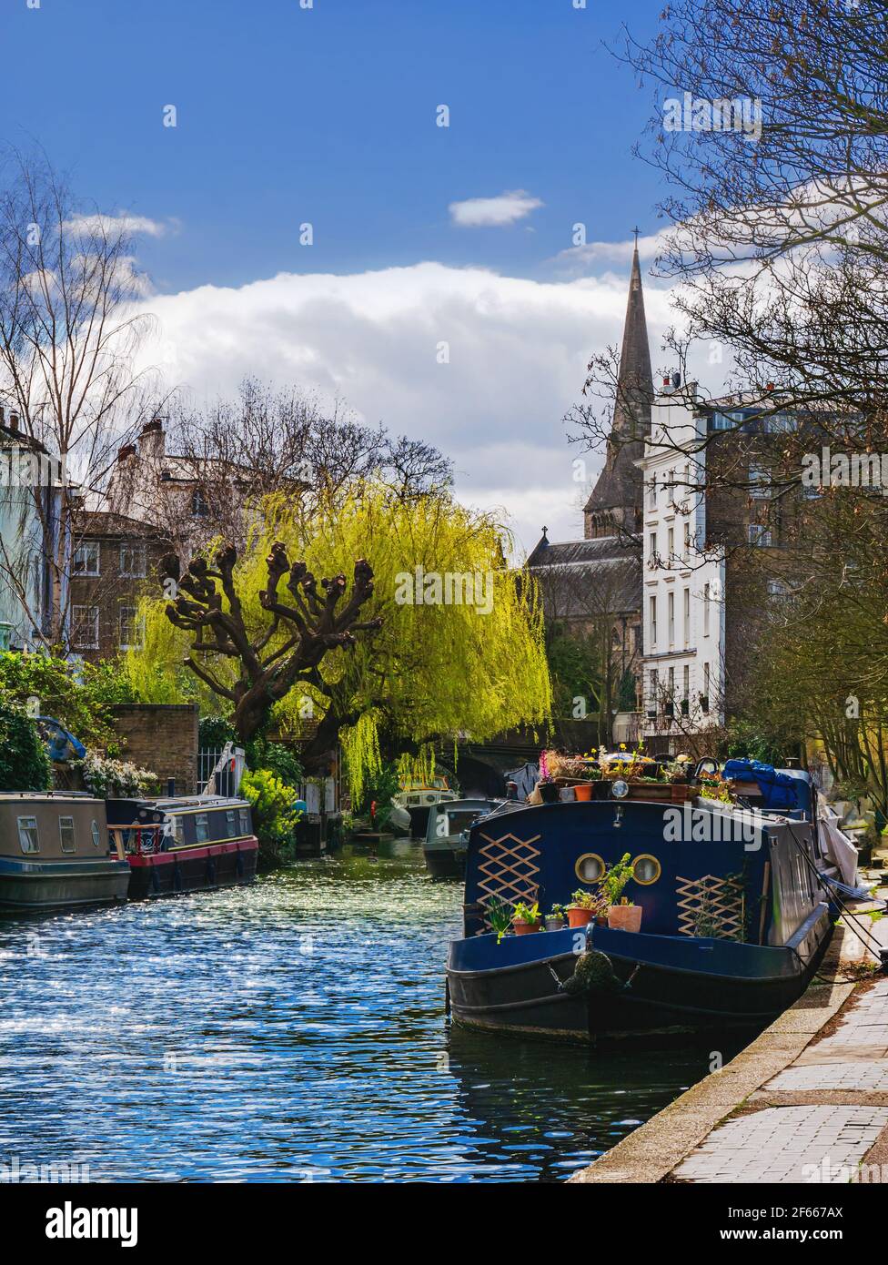 Grand Union Canal nella stagione primaverile con un motoscafo attraccato in una giornata di sole a Londra, Inghilterra Foto Stock