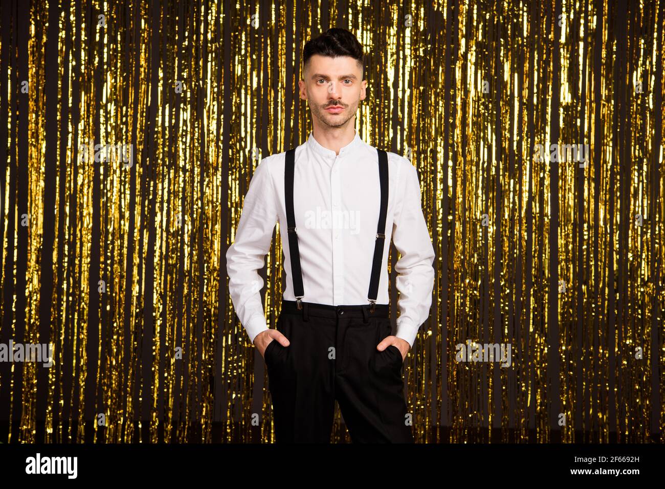 Foto di un giovane bell'uomo sicuro e serio in tasca festa di formalwear isolato su sfondo di colore glitter Foto Stock