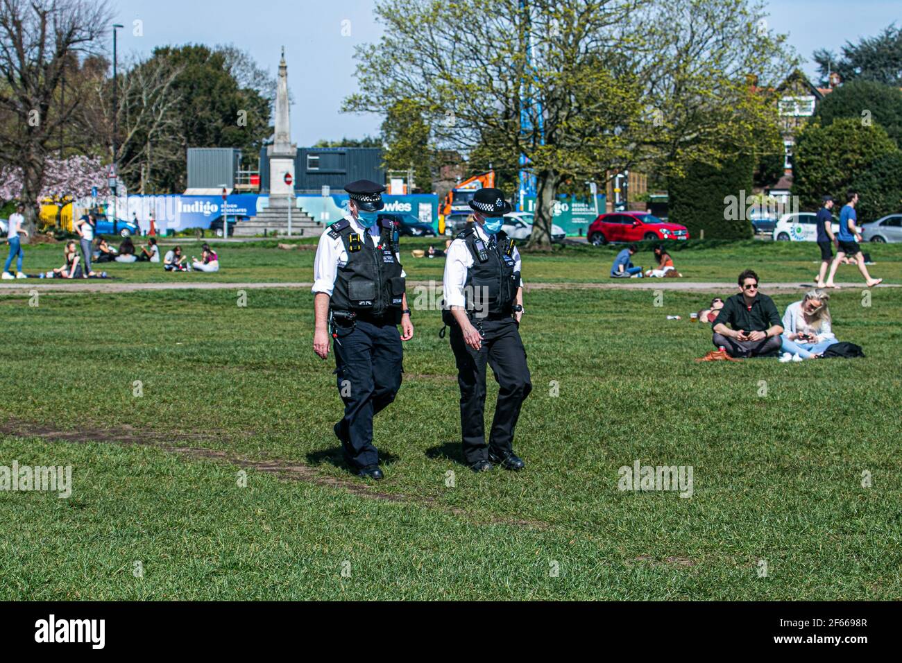 WIMBLEDON LONDRA, REGNO UNITO 30 MARZO 2021. Gli agenti di polizia camminano tra le folle, mentre il caldo sole primaverile ha incoraggiato persone e amici a incontrarsi all'aperto su Wimbledon Common un giorno dopo che le restrizioni di blocco sono state attenuate consentendo a un massimo di sei persone di incontrarsi all'aperto. Credit amer Ghazzal/Alamy Live News Foto Stock