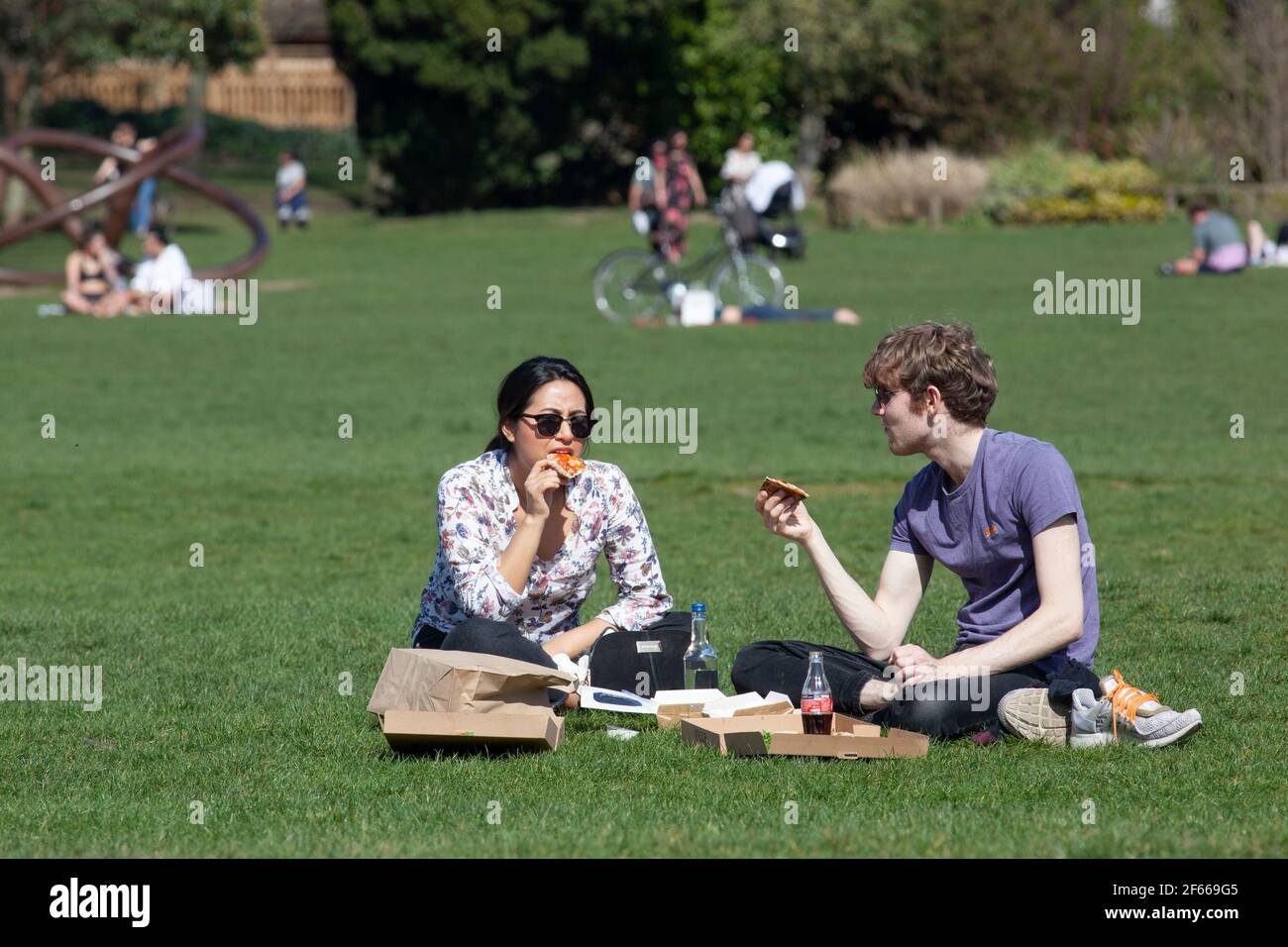 Londra, Regno Unito. Marzo 30 2021: Nel Parco di Dulwich il clima caldo e inestetonabile attira la gente fuori a prendere il sole, pic-nic, esercizio o semplicemente rilassarsi con gli amici o un buon libro. La riduzione del blocco da restrizioni del coronavirus ora significa che fino a 6 persone o due famiglie possono incontrarsi in giardini pubblici o privati. Credit: Anna Watson/Alamy Live News Foto Stock