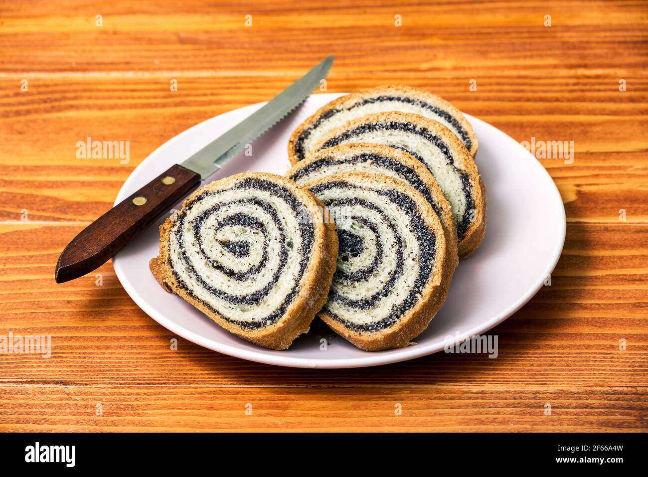 Torta di semi di papavero fatta in casa su vecchio tavolo di legno - vista laterale, dessert e decorazione per Natale, arrotolato tradizionale torta di papavero Foto Stock