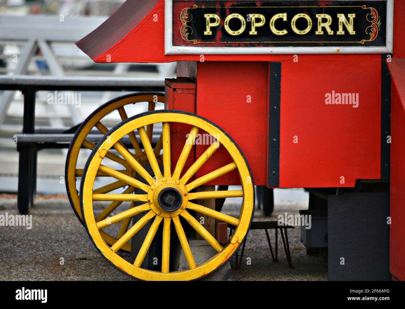Carretto di popcorn in legno rosso d'epoca con ruote gialle luminose sul molo del porto di Santa Cruz in California, Stati Uniti. Foto Stock