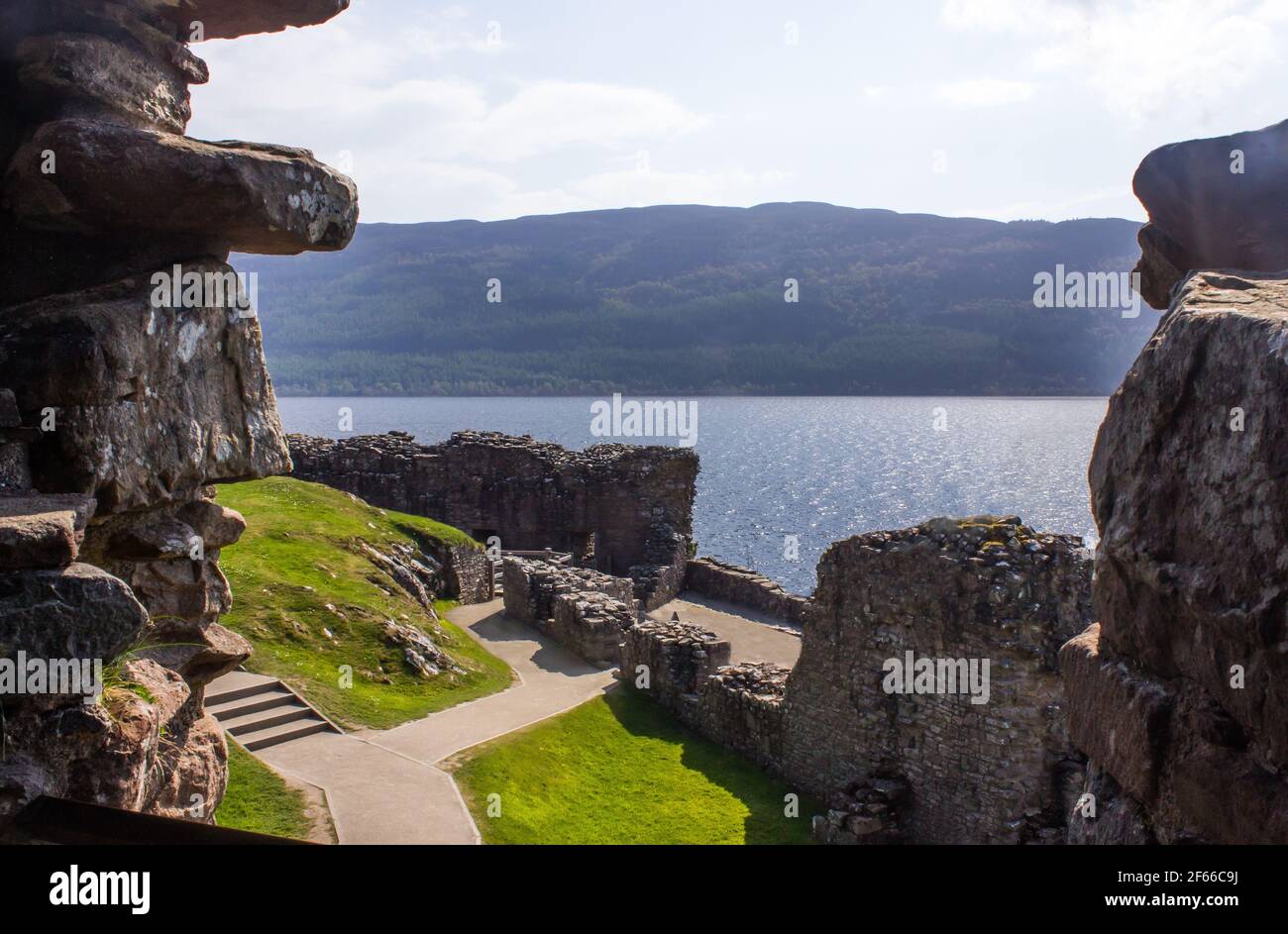 Vista sul Loch Ness e sulle montagne sulla riva opposta Attraverso le rovine del castello di Urquhart Foto Stock