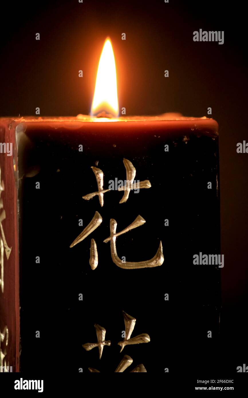 Candela nera con lettere giapponesi che bruciano su sfondo nero Foto stock  - Alamy