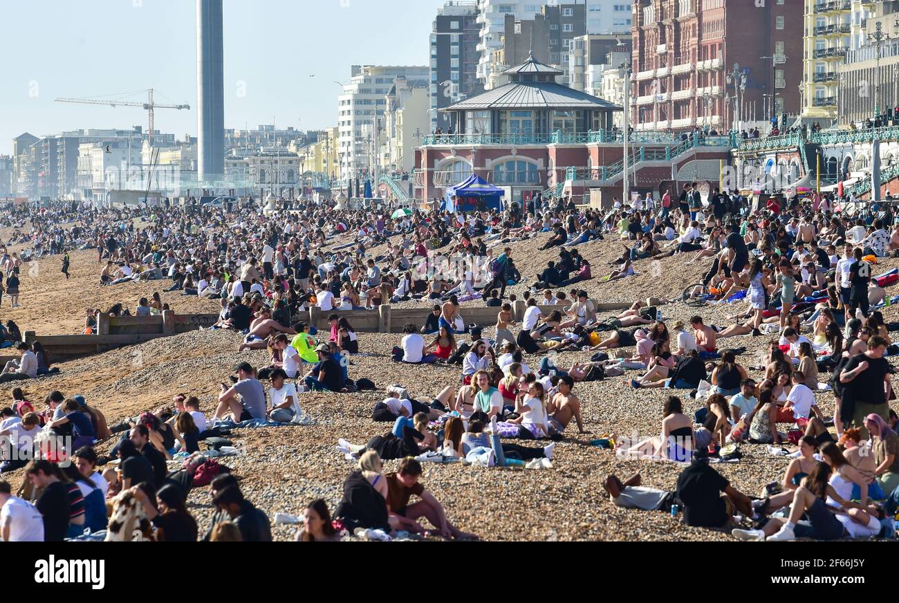 Brighton UK 30 marzo 2021 - Brighton Beach è piena di visitatori che affollano il mare il giorno più caldo dell'anno, con temperature che raggiungono la metà degli anni '20 centigradi in alcune parti del Sud Est: Credit Simon Dack / Alamy Live News Foto Stock