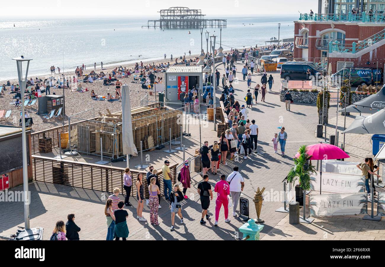 Brighton UK 30 marzo 2021 - la coda dei servizi igienici pubblici si estende lungo il lungomare di Brighton, mentre i visitatori si affollano sul mare il giorno più caldo dell'anno, con temperature che raggiungono la metà degli anni '20 centigradi in alcune parti del Sud-Est : Credit Simon Dack / Alamy Live News Foto Stock