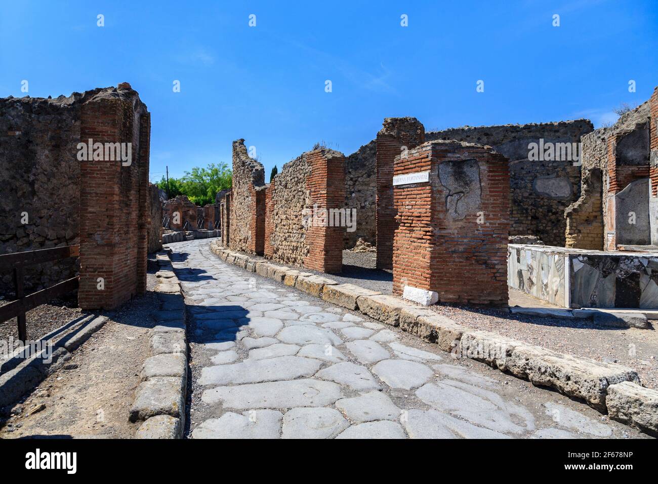 Una strada attraverso le case in rovina della città romana di Pompei, Italia Foto Stock