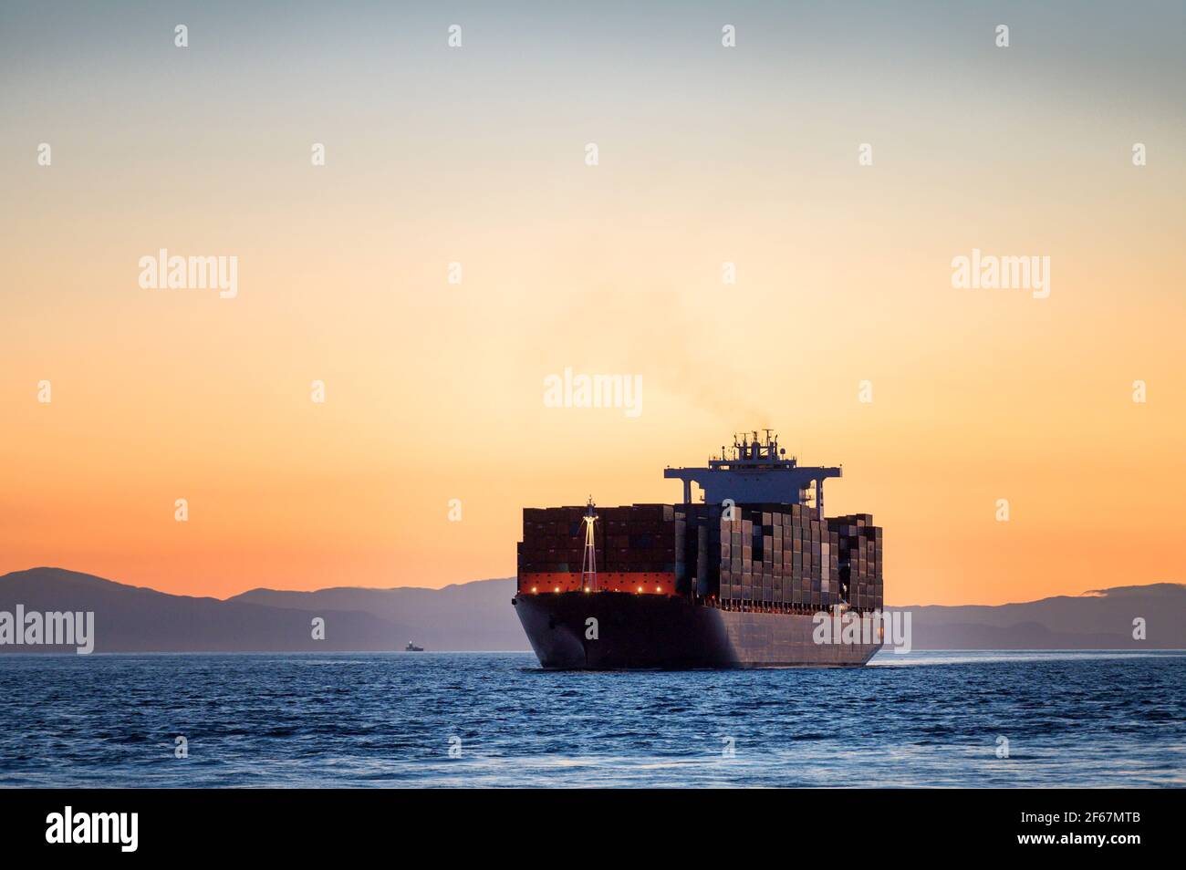 Un container naviga nel porto di Vancouver da English Bay. Foto Stock