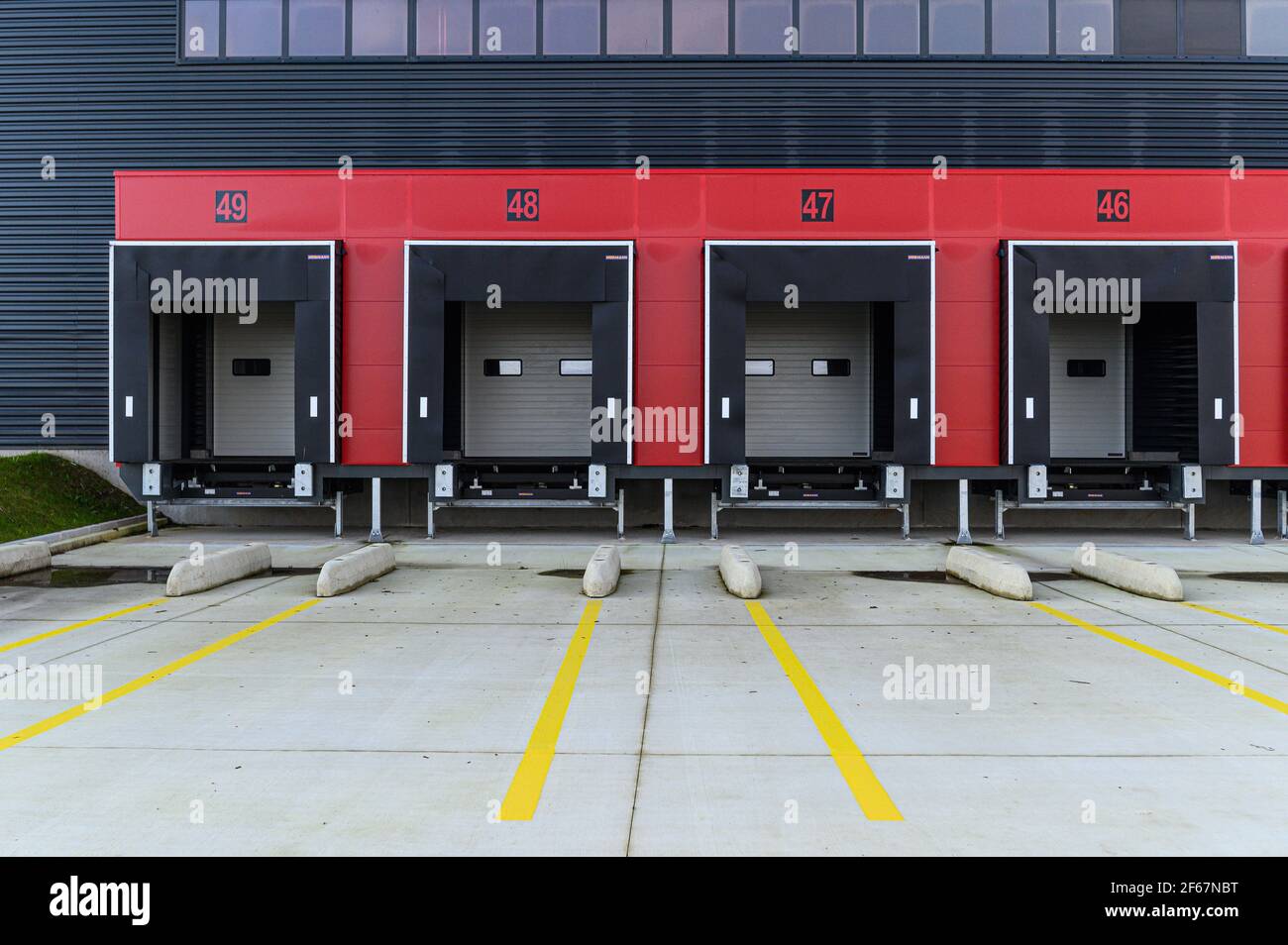 Vista su quattro vani di carico vuoti per il carico/scarico di merci o materiale. Trasporti e logistica, edilizia industriale moderna e tecnologia. Foto Stock