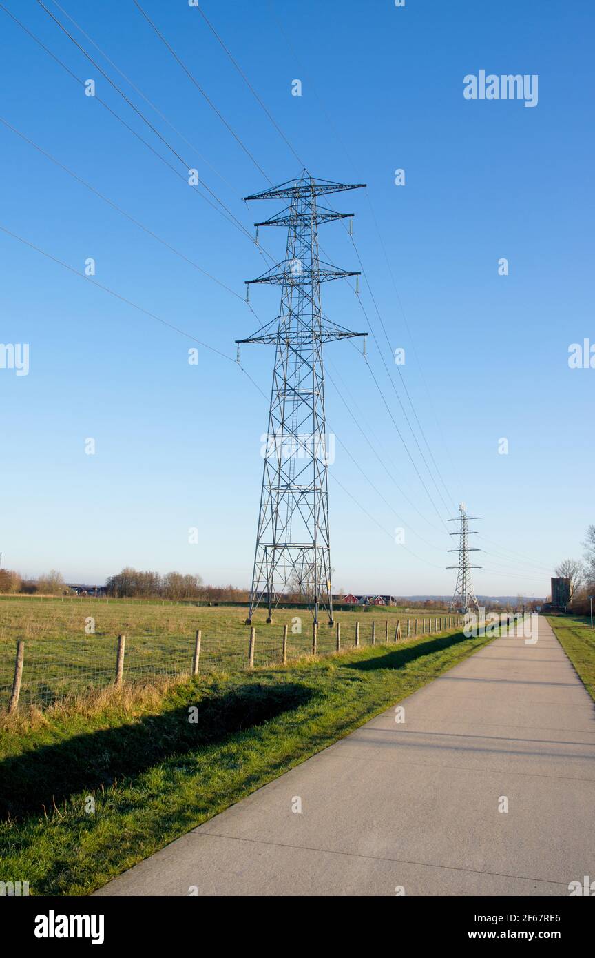 Palo di elettricità per il trasporto di elettricità in un prato con un cielo blu chiaro Foto Stock