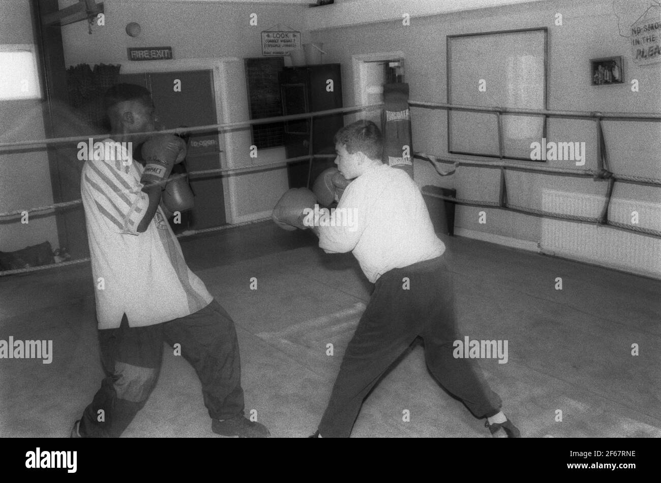 I ragazzi si allenano con l'allenatore al club di boxe Foto Stock