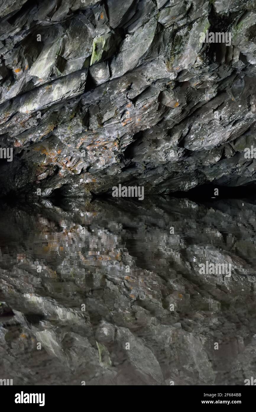 Il soffitto roccioso della Grotta di Rydal in Cumbria si specchiava nel lago Foto Stock