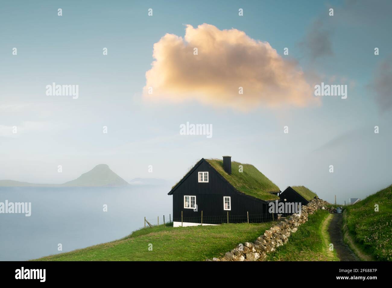 Vista mattutina foggy di una casa con tipico tetto in erba Foto Stock