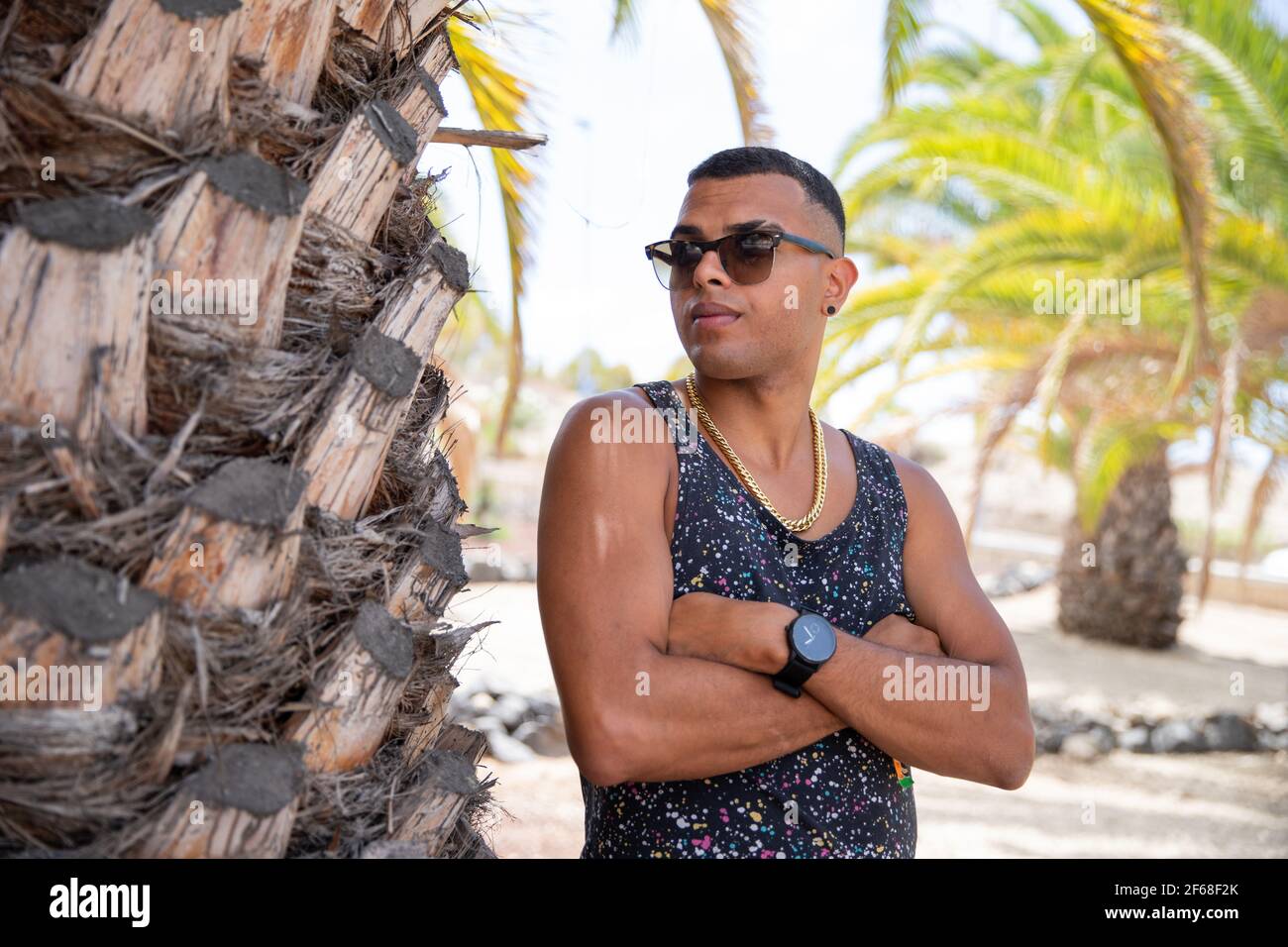 Il giovane ragazzo marocchino si pone con le braccia e gli occhiali da sole piegati in estate. Foto Stock
