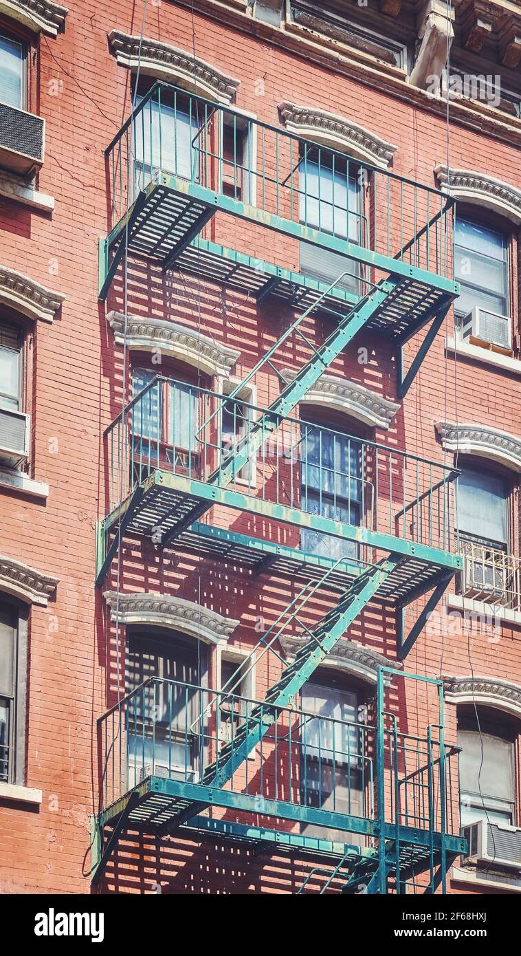Vecchio edificio in mattoni con fuga dal fuoco di ferro, colore applicato tonificante, New York City, Stati Uniti. Foto Stock