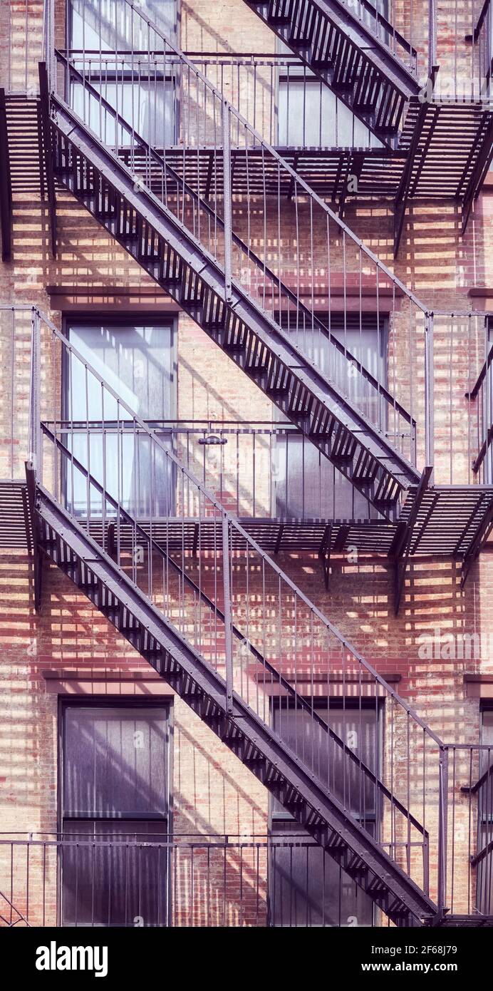 Vecchio edificio in mattoni con fuga dal fuoco di ferro, colore applicato tonificante, New York City, Stati Uniti. Foto Stock