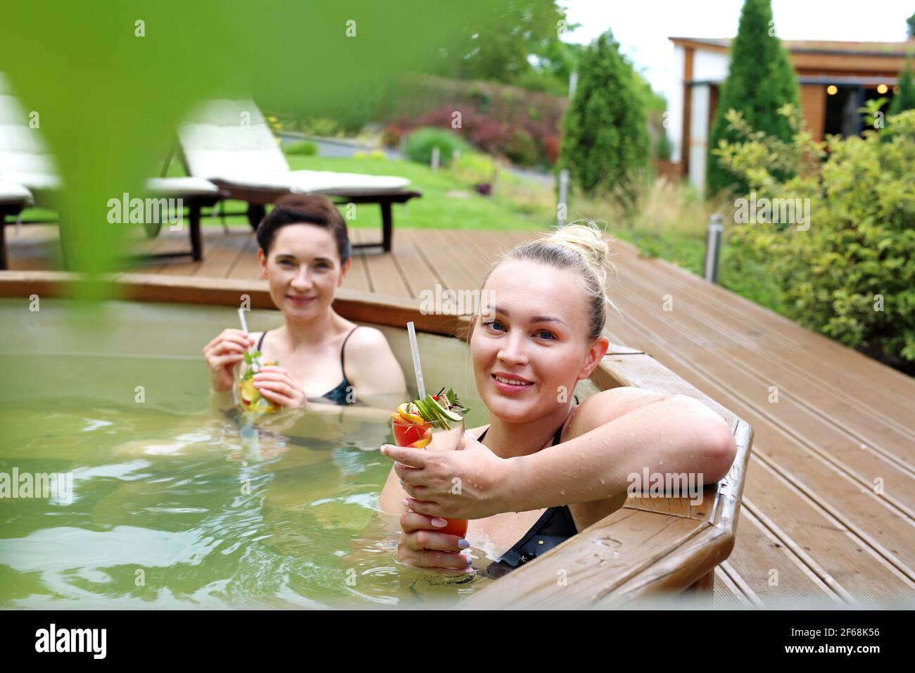 Bagno in vasca idromassaggio. Due belle donne godono di un bagno rilassante nella vasca. Amici della ragazza al centro benessere. Foto Stock