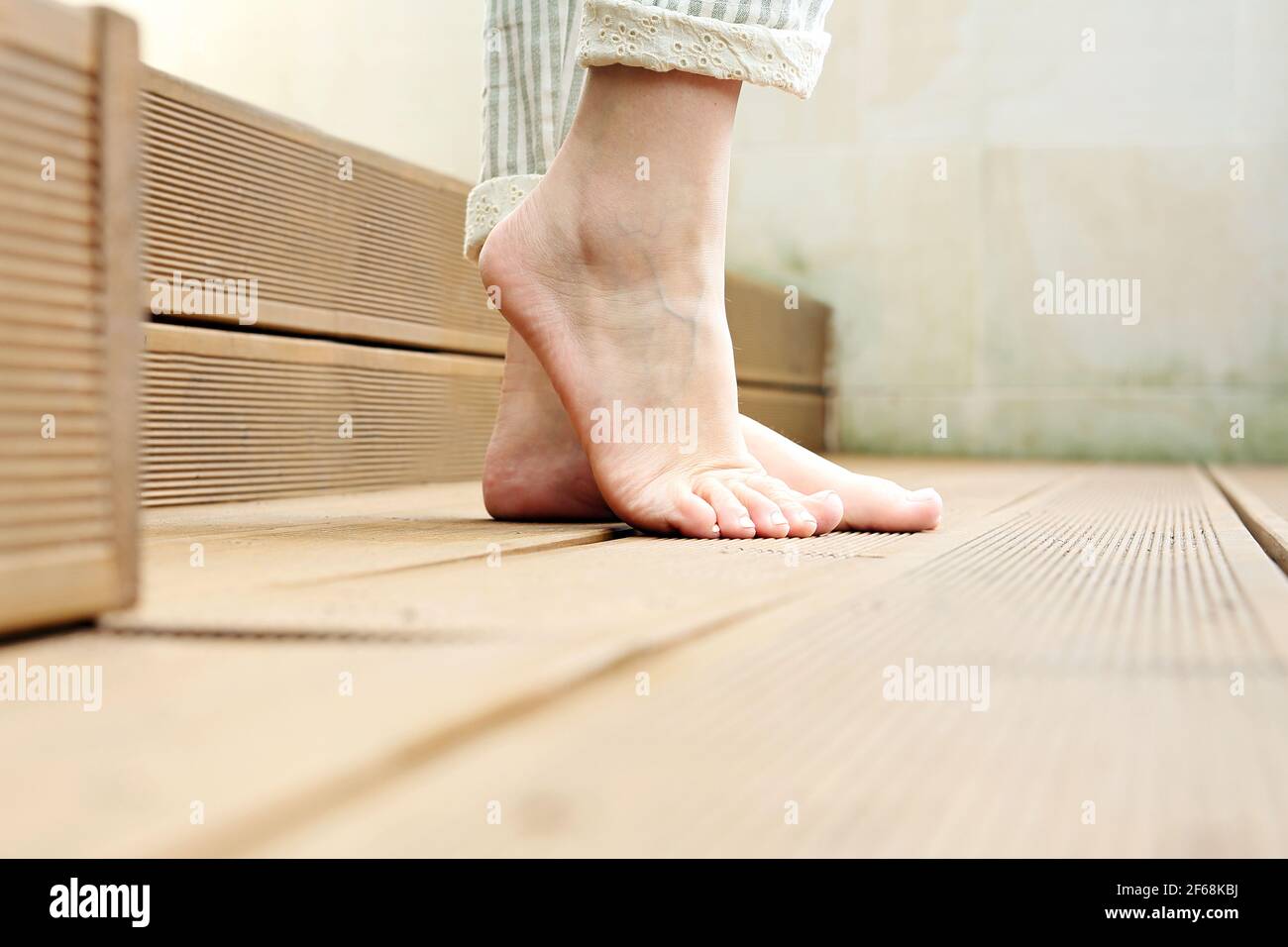 Piedi nudi. Una donna è in piedi nudi sul pavimento di legno. Foto Stock