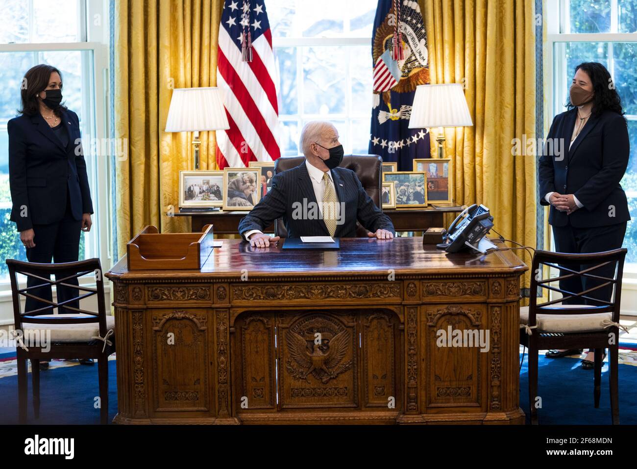 Washington, Stati Uniti. 30 Marzo 2021. Il presidente Joe Biden firma il PPP Extension Act del 2021 in legge nell'ufficio ovale con il vice presidente Kamala Harris, a sinistra e l'amministratore dell'SBA Isabel Guzman, a destra, guardando sopra, alla Casa Bianca a Washington, DC martedì, marzo 30 2021. Foto della piscina di Doug Mills/UPI Credit: UPI/Alamy Live News Foto Stock