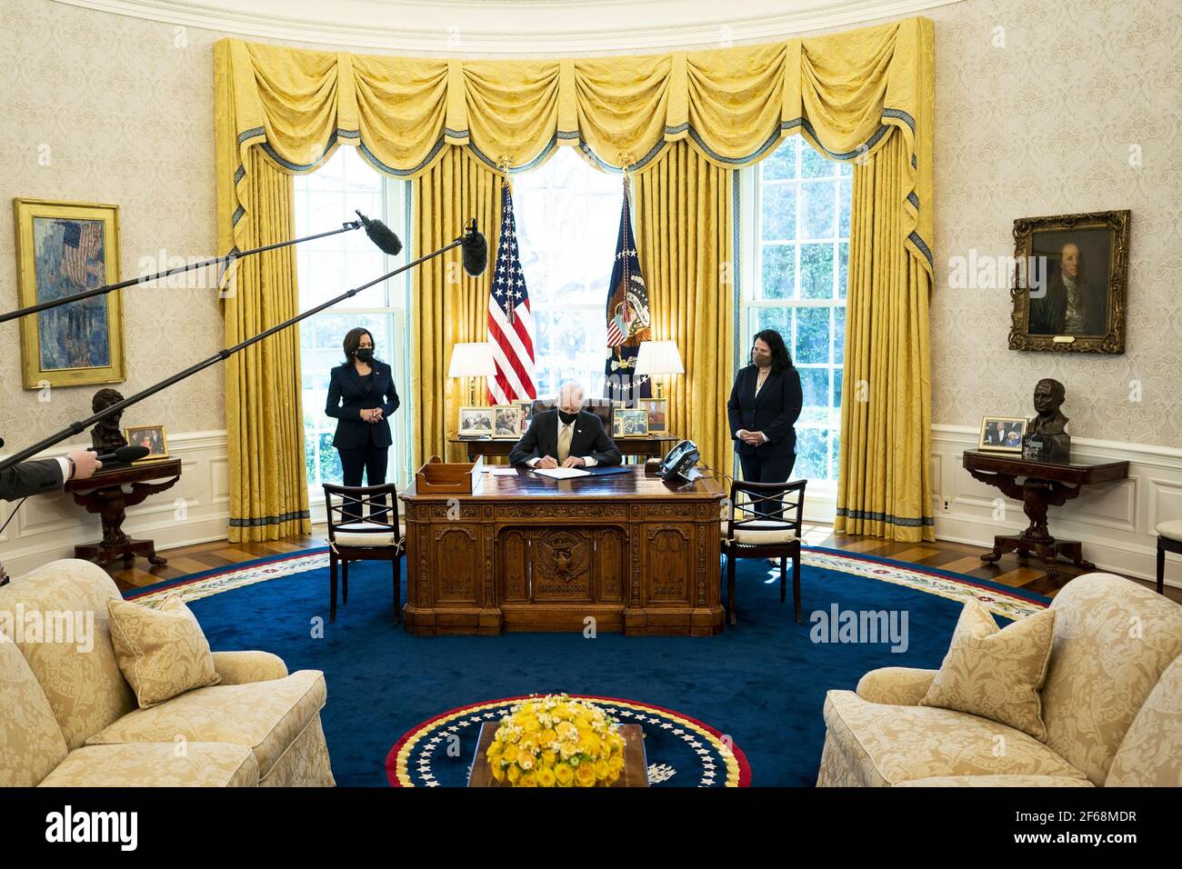 Washington, Stati Uniti. 30 Marzo 2021. Il presidente Joe Biden firma il PPP Extension Act del 2021 in legge nell'ufficio ovale con il vice presidente Kamala Harris, a sinistra e l'amministratore dell'SBA Isabel Guzman, a destra, guardando sopra, alla Casa Bianca a Washington, DC martedì, marzo 30 2021. Foto della piscina di Doug Mills/UPI Credit: UPI/Alamy Live News Foto Stock