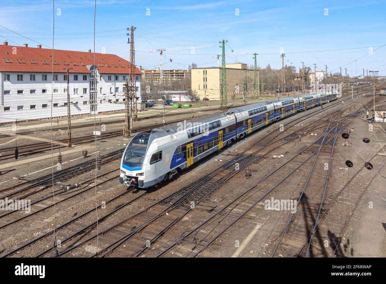 Un treno Stadler KISS EMU (H-Start 815 006) in un cantiere ferroviario mentre si avvicina alla stazione ferroviaria di Nyugati a Budapest, Ungheria Foto Stock