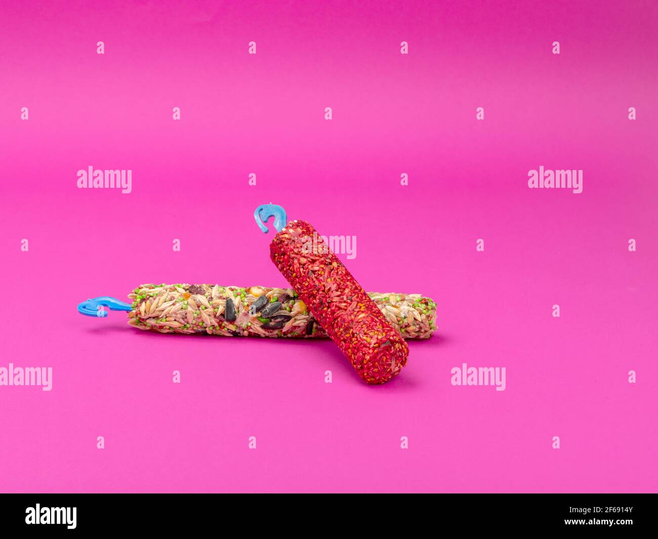 Cibo per roditori su sfondo rosa. Dieta in bacchette per animali domestici. Foto Stock