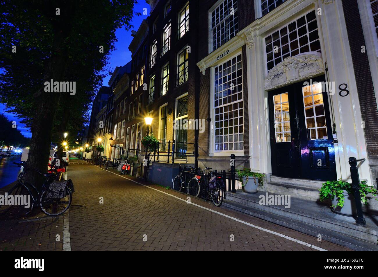 Biciclette sul canale di Amsterdam, Paesi Bassi di notte illuminate da luci colorate. Notte. Bicykle. Foto Stock