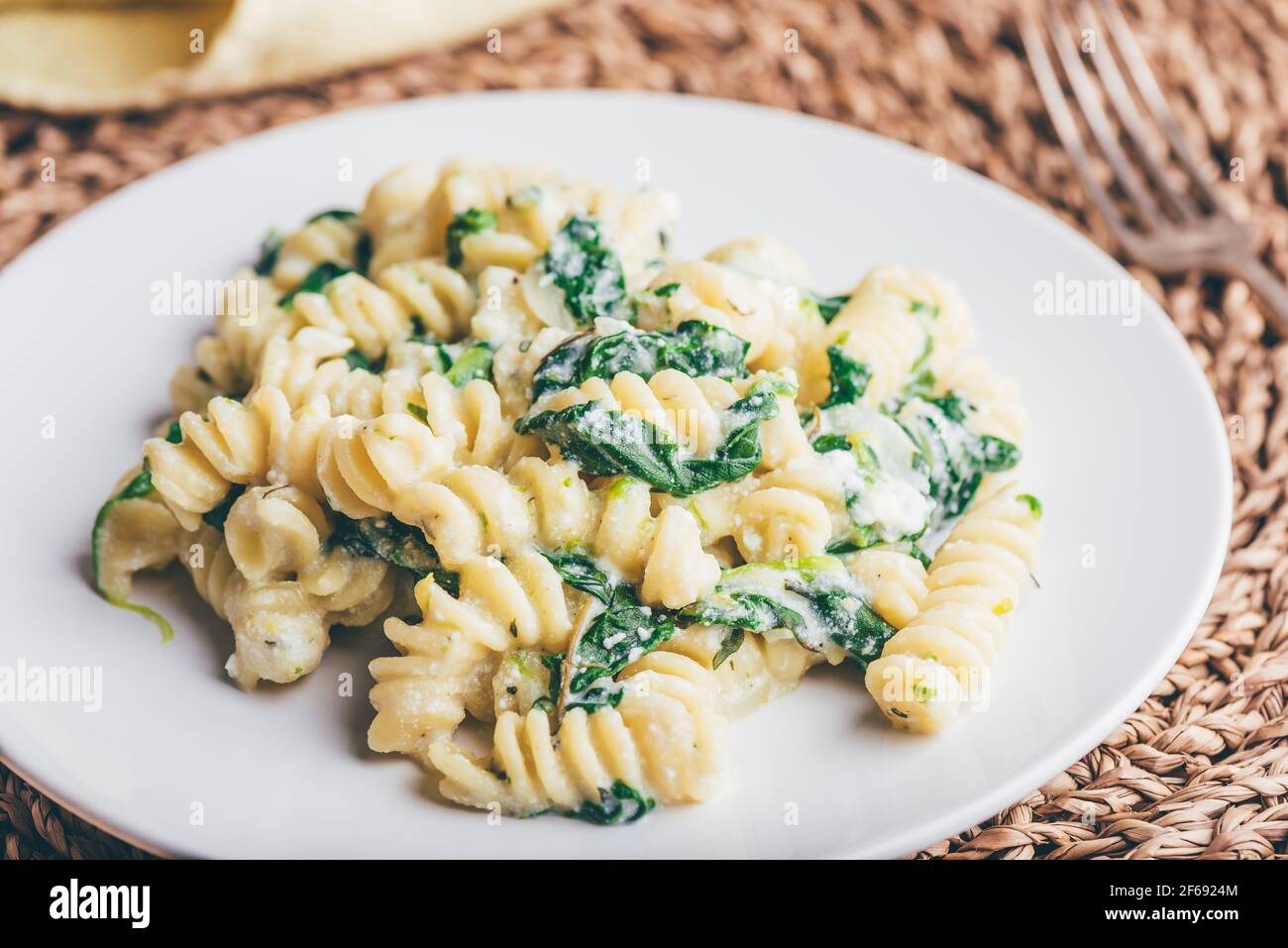 Pasta cremosa con spinaci e Timo su piatto bianco Foto Stock