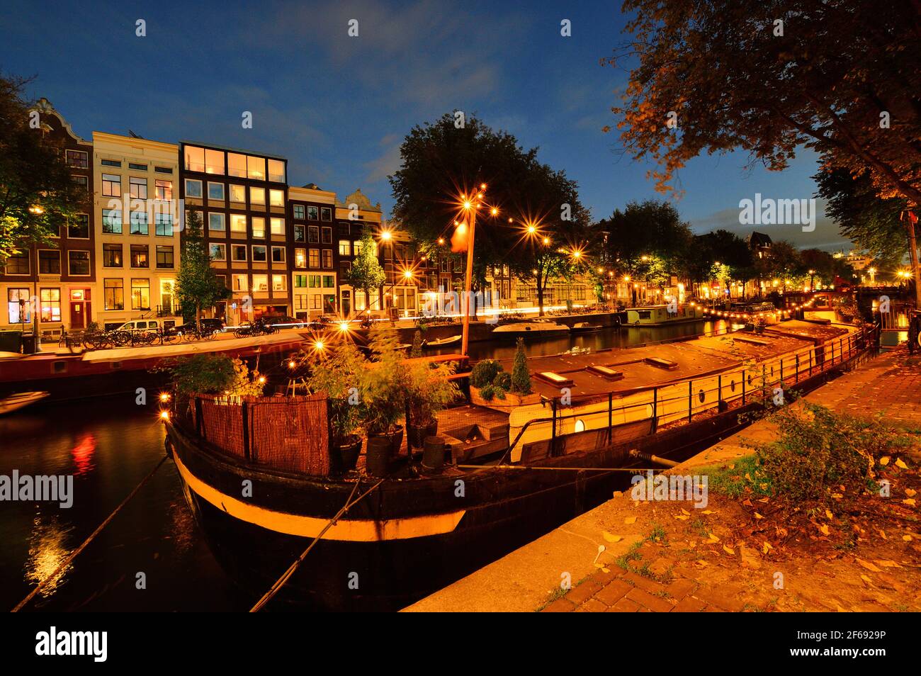 Casa galleggiante sul canale di Amsterdam di notte. Colorato. Foto Stock